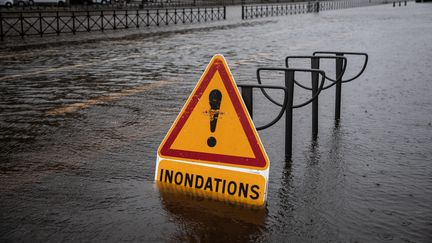 Un panneau " attention inondations " en partie sous l'eau. Photo d'illustration. (GUILLAUME SALIGOT / MAXPPP)