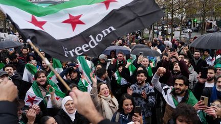 Des membres de la communauté syrienne célèbre la chute du régime de Bachar Al Assad, place de la République à Paris, le 8 décembre 2024. (DIMITAR DILKOFF / AFP)