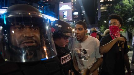 De jeunes hommes interpellent des policiers, à Charlotte (Caroline du Nord), mercredi 22 septembre 2016.&nbsp; (NICHOLAS KAMM / AFP)