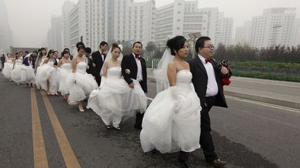 Des couples se dirigent vers le lieu de r&eacute;ception, apr&egrave;s que des mariages ont &eacute;t&eacute; c&eacute;l&eacute;br&eacute;s en masse, le 10 octobre 2010 &agrave; P&eacute;kin (Chine). (CHRISTINA HU / REUTERS )