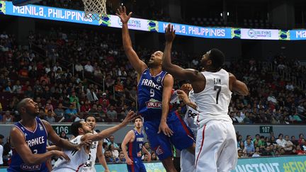 Tony Parker fait face au Canadien Melvin Ejim, dimanche 10 juillet 2016 en finale du Tournoi de qualification olympique de Manille (Philippines). (TED ALJIBE / AFP)