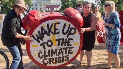 Des manifestants devant la Maison Blanche protestent contre la décision de&nbsp;Donald Trump de se retirer de l'accord de Paris sur le climat, le 1er juin 2017, à Washington (Etats-Unis). (PAUL J. RICHARDS / AFP)