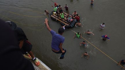 Bloqués sur le pont reliant le Guatemala au Mexique, certains migrants n'ont pas hésité à sauter dans la rivière Suchiate pour franchir la frontière, le 20 octobre 2018. (EDWIN BERCIAN / EFE / SIPA)