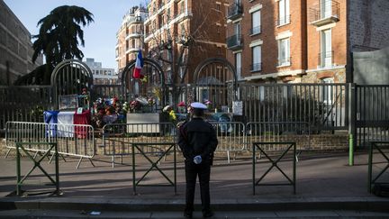 Un policier à Montrouge (Hauts-de-Seine), le 8 janvier 2018, devant le lieu où la policière municipale Clarissa Jean-Philippe a été tuée par un terroriste&nbsp;trois ans plus tôt. (ETIENNE LAURENT / EPA)