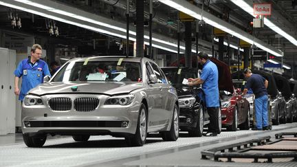 Des ouvriers travaillent sur une cha&icirc;ne d'assemblage du constructeur allemand BMW dans son usine de Dingolfing, dans le sud de l'Allemagne, le 23 mars 2012. (CHRISTOF STACHE / AFP)