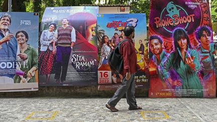 Un passant devant des affiches de films aux abords d'un multiplexe de Bombay (Inde), le 1er octobre 2022. (PUNIT PARANJPE / AFP)