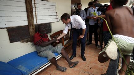 Le président français Emmanuel Macron s'adressant, le 12 septembre 2017, à un habitant de Saint-Martin, l'île des Antilles frappée par l'ouragan Irma. (CHRISTOPHE ENA / POOL / AFP)