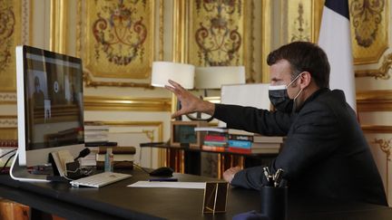 Le président de la République, Emmanuel Macron, échange par visioconférence avec des collégiens des Alpes-de-Haute-Provence, mardi 6 avril 2021 depuis le palais de l'Elysée à Paris. (CHRISTOPHE ENA / AFP)