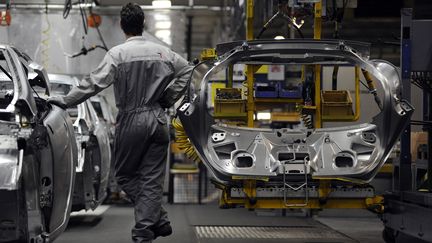 Un ouvrier de l'usine PSA de Sochaux-Montb&eacute;liard (Doubs) travaille sur une cha&icirc;ne d'assemblage, le 18 mars 2009. (SEBASTIEN BOZON / AFP)