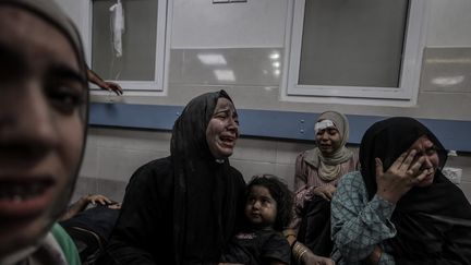 Des Palestiniennes, blessées, pleurent après la frappe meurtrière sur l'hôpital Ahli Arab à Gaza, le 17 octobre 2023. (ALI JADALLAH / ANADOLU / AFP)