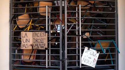 Des chaises et des bureaux bloquent une entrée du site Schuman de l'université &nbsp;Aix-Marseille 1, le 17 avril. "La fac est un droit, pas une boîte de luxe", peut-on lire sur les affiches accrochées&nbsp;aux barreaux.&nbsp; (BERTRAND LANGLOIS / AFP)