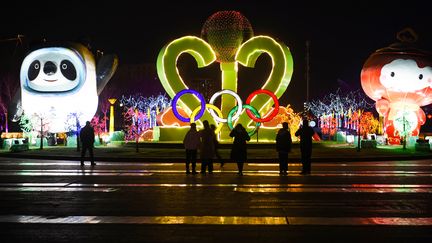 Personnes visitant un spectacle de lanternes sur le thème des Jeux Olympiques et Paralympiques d'hiver de Beijing 2022 sur la place du citoyen à Zhangjiakou, dans le nord de la province du Hebei. (STR / AFP)