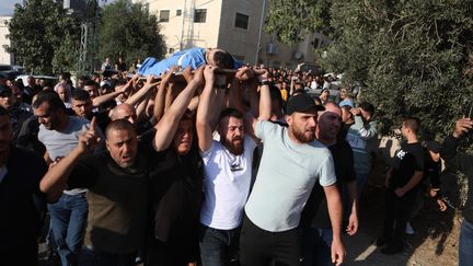 Des personnes participent aux obsèques d'un Palestinien tué lors d'affrontements avec les forces israéliennes, le 13 octobre 2023, à Hébron, en Cisjordanie occupée. (MAMOUN WAZWAZ / ANADOLU / AFP)