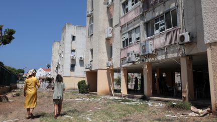 Des habitantes de la ville d'Acre dans le nord d'Israël constatent les dégâts causés par l'assaut du Hezbollah, le 25 août 2024. (JACK GUEZ / AFP)