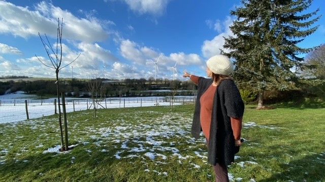 Derrière la maison&nbsp;d'Aurélie, une habitante Echauffour dans l'Orne, avec les éoliennes en arrière-plan.&nbsp; (MARC BERTRAND / RADIOFRANCE)