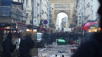 Des policiers face à des manifestants kurdes, lors d'un rassemblement survenu après une attaque, rue d'Enghien, dans le 10e arrondissement de Paris, le 23 décembre 2022. (THOMAS SAMSON / AFP)