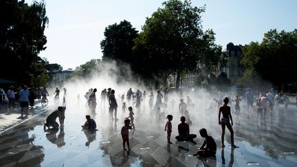 Des enfants se rafraîchissent dans une fontaine à Nantes, le 26 août 2016. (JEAN-SEBASTIEN EVRARD / AFP)