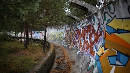 A cause de la guerre de Yougoslavie, la plupart des infrastructures olympiques construites à Sarajevo ont été détruites huit ans après les JO de 1984 à Sarajevo (Bosnie-Herzégovine). Abandonnée, la piste de bobsleigh, photographiée en 2013, est devenue un lieu d’expression pour les graffeurs. (DADO RUVIC / REUTERS)