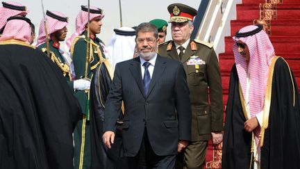 Le pr&eacute;sident &eacute;gyptien Mohamed Morsi (au centre) &agrave; l'a&eacute;roport de Riyad (Arabie saoudite), le 21 janvier 2013. (FAYEZ NURELDINE / AFP)