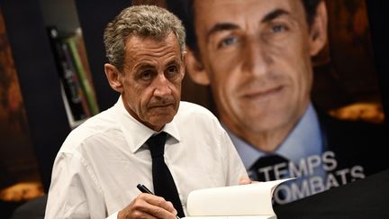 Nicolas Sarkozy lors d'une séance de dédicaces, à Arcachon (Gironde), le 25 août 2023. (CHRISTOPHE ARCHAMBAULT / AFP)