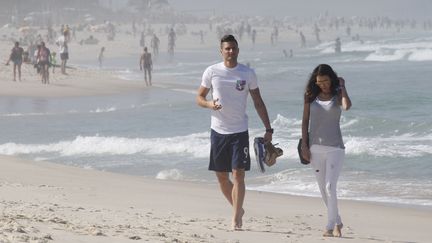 Olivier Giroud et son &eacute;pouse, Jennifer, sur la plage de Barra da Tijuca, &agrave; Rio de Janeiro (Br&eacute;sil), le 26 juin 2014. (TAAMALLAH MEHDI / SIPA)