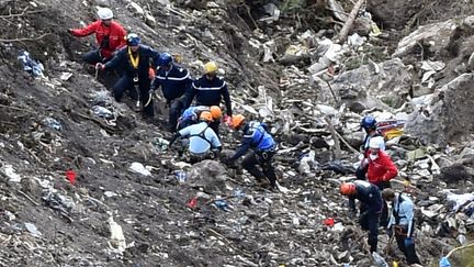 Des enqu&ecirc;teurs sur les lieux du crash de l'Airbus A320 de la compagnie Germanwings dans les Alpes-de-Haute-Provence, le 26 mars 2015. (ANNE-CHRISTINE POUJOULAT / AFP)