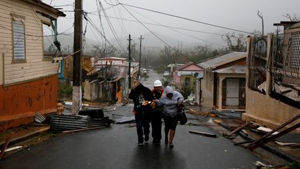 Des sauveteurs aident des habitants à Guayama, à Porto Rico, le 20 septembre 2017. (CARLOS GARCIA RAWLINS / REUTERS)