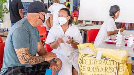 Une soignante vaccine un homme dans un centre de vaccination de Papeete, en Polynésie française, le 4 septembre 2021.&nbsp; (JEROME BROUILLET / AFP)