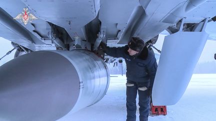 Un militaire russe examine un intercepteur MiG-31K, portant un missile hypersonique Kinzhal. (HANDOUT / RUSSIAN DEFENCE MINISTRY)