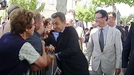 Nicolas Sarkozy pris par sa veste à Brax (Lot-et-Garonne) (AFP/France Televisions)