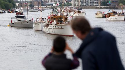 Des passants observent les bateaux qui participeront &agrave; la parade pr&eacute;vue pour le jubil&eacute; de la reine Elizabeth II samedi 2 juin sur la Tamise, &agrave; Londres (Royaume-Uni). (ANDREW COWIE / AFP)