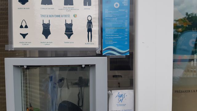 Un tableau avec des pictogrammes simples pour les tenues autorisées à la piscine de Surgères, (Charente-Maritime) dont le burkini (Photo d'illustration août 2019). (JULIEN FLEURY / RADIO FRANCE)