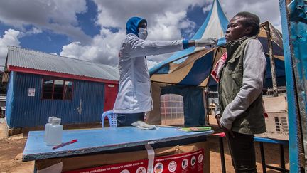 Un agent de santé prend la température d'un homme par mesure de prévention. Le directeur général de l'OMS, Tedros Adhanom Ghebreyesus, et le coordinateur de l'aide d'urgence des Nations unies, Mark Lowcock, ont appelé la communauté internationale à soutenir les Etats dont les systèmes de santé sont faibles pendant la crise. Au Kenya, un pays de 50 millions d'habitants, il n’existe que 130 lits de soins intensifs. Peu de personnes ont une assurance maladie. Et les tests trop peu nombreux.&nbsp; &nbsp; (DONWILSON ODHIAMBO / SOPA IMAGES / SIPA)