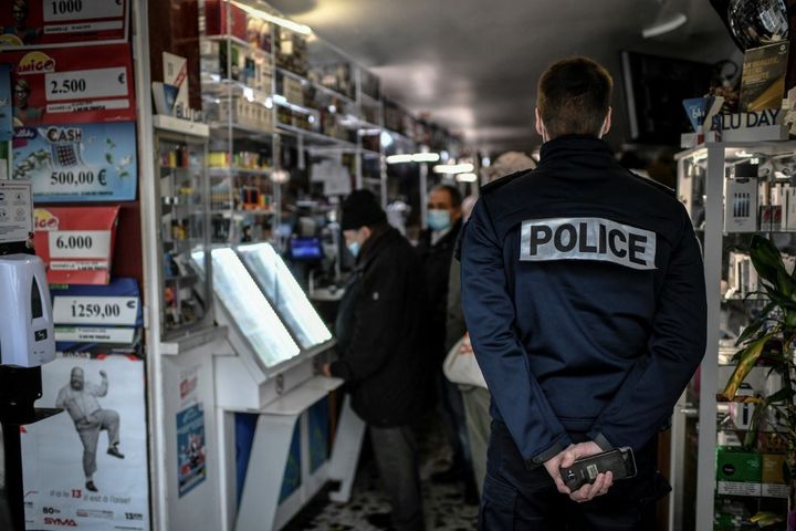 Un policier contrôle l'intérieur d'un bar à Paris, le 3 février 2021. (STEPHANE DE SAKUTIN / AFP)