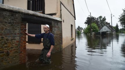 Un habitant de "La Gueroulde", à côté de Breteuil (Normandie),&nbsp;se tient dans sa rue,&nbsp;inondée. L'Iton&nbsp;est sorti de son lit suite aux pluies le 5 juin 2018. (JEAN-FRANCOIS MONIER / AFP)