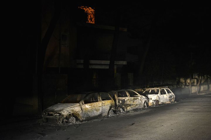 Des voitures brûlées le 23 juillet 2018 à Mati (Grèce). (ANGELOS TZORTZINIS / AFP)