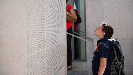 Un enfant devant le Mur des Noms, au Mémorial de la Shoah, à Paris, en 2018. (GA?L DUPRET / MAXPPP)