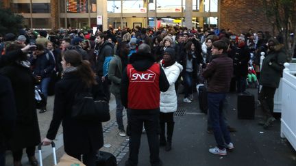 Un agent de la SNCF conseille des passagers après un incident à la gare de Bercy, le 23 décembre 2017, à Paris. (JACQUES DEMARTHON / AFP)