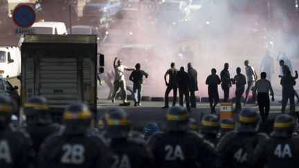 Des CRS face &agrave; des chauffeurs de taxis qui manifestent &agrave; Paris, &agrave; la porte Maillot, le 25 juin 2015. (KENZO TRIBOUILLARD / AFP)