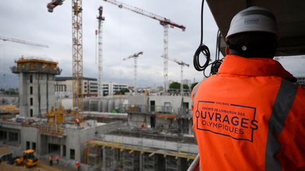 Un ouvrier observe le chantier du village olympique (mai 2023). (FRANCK FIFE / AFP)