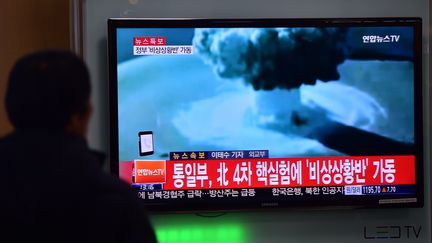 Un passant regarde à la télévision un reportage rapportant l'essai d'une bombe H en Corée du Nord, le 6 janvier 2016 à Séoul (Corée du Sud). (JUNG YEON-JE / AFP)