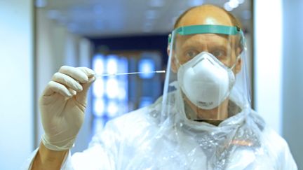 Un biologiste présente un écouvillon utilisé pour les prélèvements naso-pharyngés. Photo prise le 11 mai 2020 à Strasbourg. (JEAN-MARC LOOS / MAXPPP)