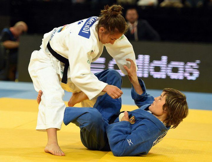 La Kosovare Majlinda Kelmendi (en blanc), sur le point de remporter son second titre de championne du monde de judo, catégorie moins de 52 kilos, face à la Russe Natalia Kuziutina (en bleu) lors de la finale, le 24 avril 2014. (PASCAL GUYOT / AFP)