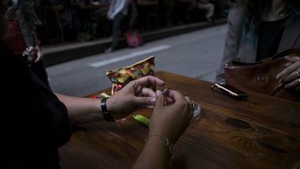 Un consommateur de cannabis roule un joint sur la table d'un bar. (© ALEXANDER ROTH-GRISARD / MAXPPP / MAXPPP)