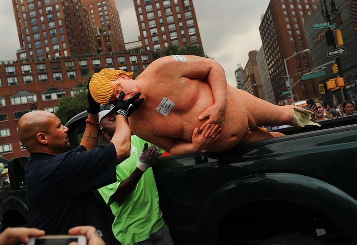 Des employés du service des parcs de New York (Etats-Unis) retirent une statue de Donald Trump installée sans autorisation dans la ville, le 18 août 2016. (SPENCER PLATT / GETTY IMAGES NORTH AMERICA / AFP)