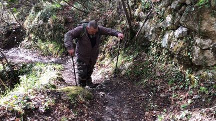 Michel Daigneau&nbsp;sur le sentier de randonnée&nbsp;qui lui permet d'atteindre son domicile dans le hameau de Sainte-Sabine à Sospel (Alpes-Maritimes), le 4 avril 2019.&nbsp; (LOUISE HEMMERLE / FRANCE INFO)