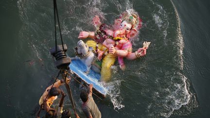 Des Indiens d&eacute;crochent d'une grue une statue de Ganesh afin de l'immerger dans les eaux du fleuve&nbsp;Sabarmati &agrave; Ahmedabad (Inde), le 29 septembre 2012. (AMIT DAVE / REUTERS)