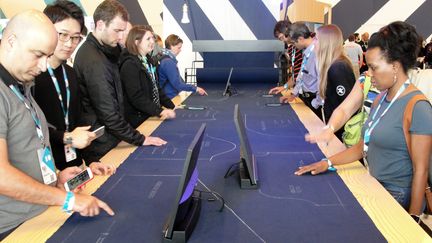 Des personnes testent&nbsp;un tissu sensible au toucher, permettant de commander des objets &agrave; distance gr&acirc;ce, d&eacute;velopp&eacute; par Google, &agrave; San Francisco, en Californie (Etats-Unis), le 29 mai 2015. (GLENN CHAPMAN / AFP)