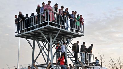 A Kilis, en Turquie, des r&eacute;fugi&eacute;s syriens observent la fronti&egrave;re. Plusieurs personnes ont &eacute;t&eacute; bless&eacute;es pr&egrave;s d'un camp de r&eacute;fugi&eacute;s par des tirs syriens&nbsp;ayant franchi la fronti&egrave;re, le&nbsp;9 avril 2012. (IHLAS NEWS AGENCY / TURKEY OUT / AFP)