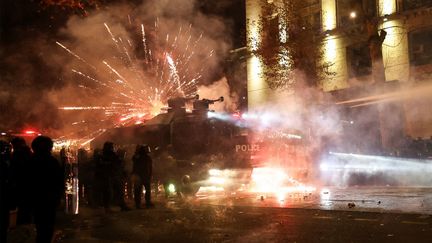 Des policiers visés par des tirs de feux d'artifice d'une manifestation pro-européenne et anti-gouvernement à Tbilissi, en Géorgie, le 2 décembre 2024. (GIORGI ARJEVANIDZE / AFP)